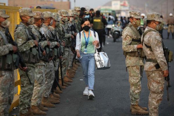 mujer_caminando_entre_militares_toque_de_queda_en_peru.jpg