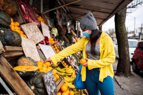 mujer-comprando-en-el-mercado-callejero-foto-bursatil-de-una-joven-con-mascarilla-que-compra-fruta-la-tienda-greengrocer-200443492.jpg