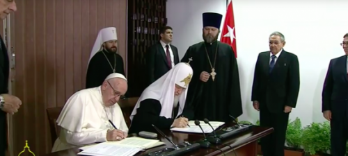 El Papa y el Patriarca sentados a la mesa firman la declaración conjunta, en presencia de Raúl Castro. papa francisco   patriarca kiril